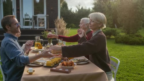 Family Gathering for Outdoor Meal Together in Garden