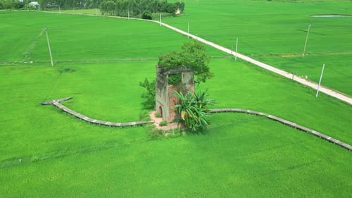 An Old Building Surrounded By Lush Green Rice Fields Connected By a Wooden Bridge Showcasing Rural