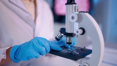 Close up of female scientist in white lab coat working in laboratory.