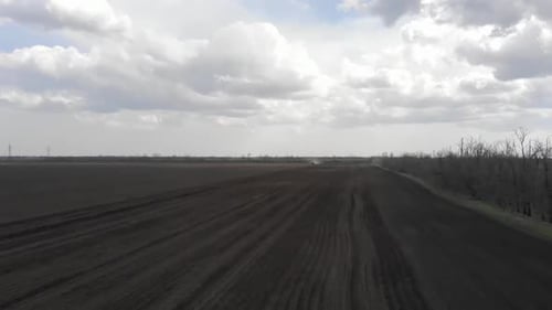 Blue tractor working on the field in Odessa in Ukraine during planting sunflower
