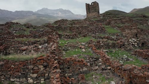 Ancient Stone Ruins with Dilapidated Tower on Mountainous Terrain