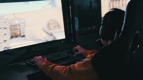 Young Gamer Sits in Gaming Chair and Plays Video Game at ESport Club
