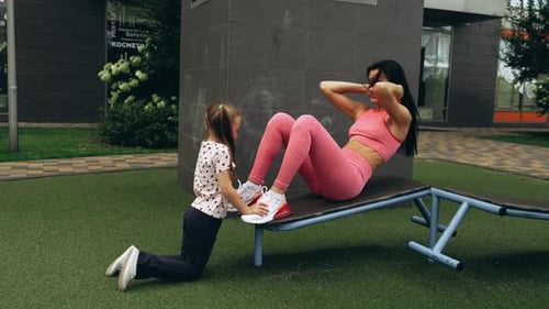Mother and Daughter Workout Together at a Park During Sunny Afternoon