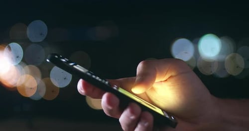 Hand Interacting with Smartphone at Night
