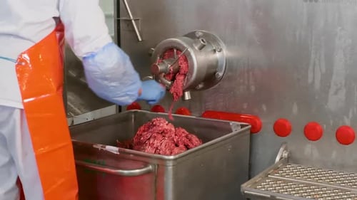 Midsection of Man Mincing Meat in Mincer at Factory