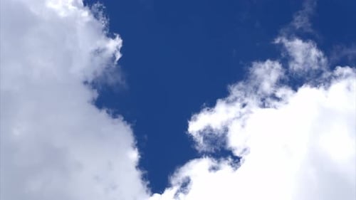 Lapa de temps de nuages blancs gonflés se déplaçant sur un ciel bleu profond