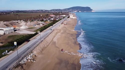 aerial view of an Italian coastline with morning light - following a car on the seafront road with t