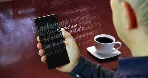 Hand Holds Cell Phone Displaying Blockchain Terms