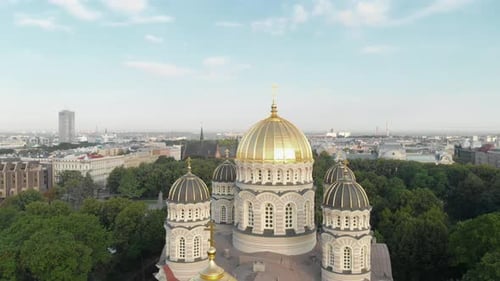 Spinning aerial view of Latvian Nativity of Christ cathedral in Esplanade park on sunny summer day,