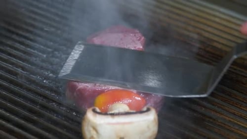 Close-up of a beef and vegetable kabob cooking on the BBQ.