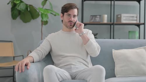 Man Talking on Cell Phone While Sitting Indoors