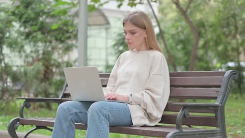 Young Woman Using Laptop in Urban Park