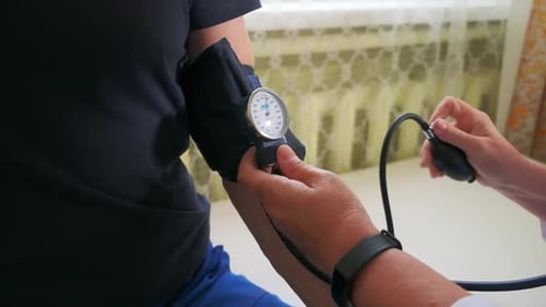 Arzt verwendet mechanisches Tonometer, um den Blutdruck eines männlichen Patienten zu überprüfen Clip Concept of Health