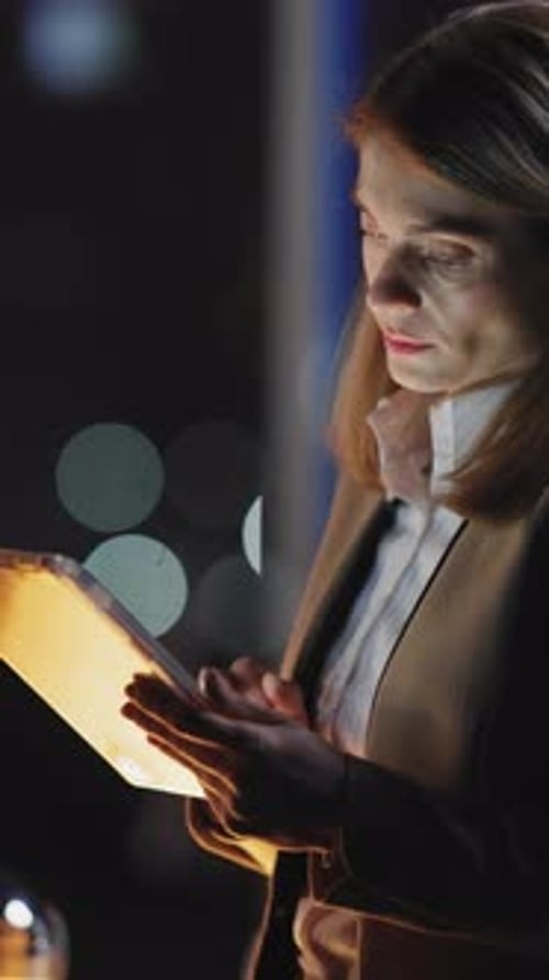 Woman Uses Tablet Device at Night in Office