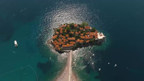 A drone view from above of the island of Sveti Stefan in Montenegro, connected to the mainland by a