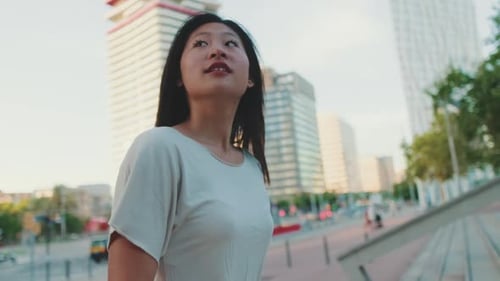 Woman Walks in a City on a Sunny Day