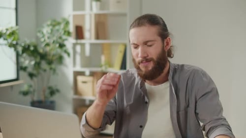 Stressed Man Massaging Temples at Computer