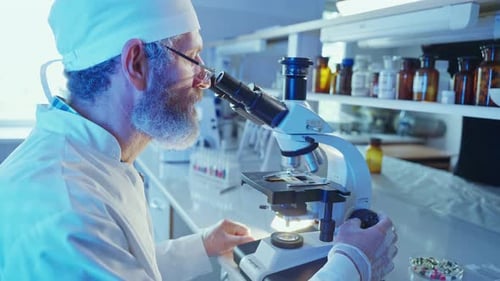 Man Using Microscope in Brightly Lit Laboratory