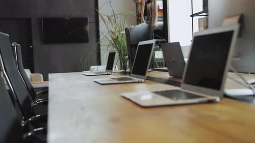 Laptops on Table in Conference Room Next to Houseplant