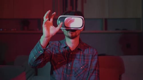 Virtual reality at home, a man in a virtual reality helmet plays, works at home