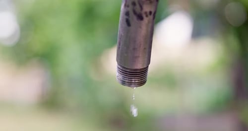 Water Drips From a Leaky Faucet with a Blurred Background Water Saving Concept
