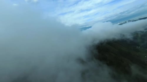 Aerial footage mountain peaks shrouded in fog.