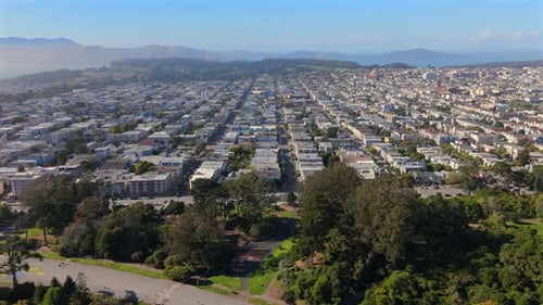 A Stunning Aerial View of an Urban Neighborhood Featuring a Vibrant Cityscape and Lush Hills