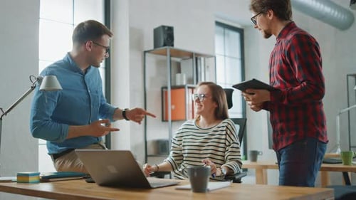Enthusiastic team celebrates achievement in modern office