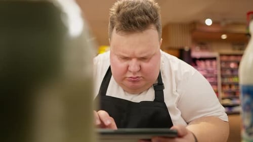 A Serious and Interested Man Does a Reinventory of Goods in a Supermarket An Overweight Man Looks