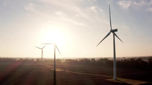 Wind Turbines That Produce Electricity Built on a Field Beautiful Sunrise
