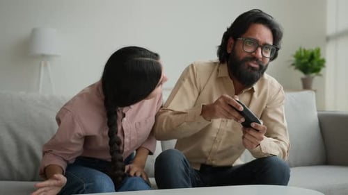 Couple playing video game on couch at home