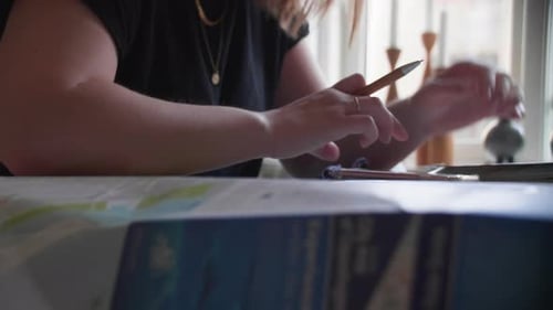 Young Adult at Desk with Papers and Pen