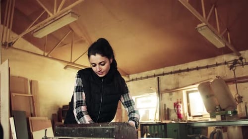 Portrait Of A Woman Worker In The Carpentry Workshop, Working With Wood.