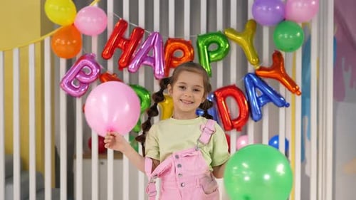 Smiling Girl Celebrates Birthday with Balloons and Decorations