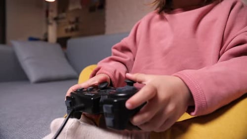 Child Playing Video Games with Controller at Home