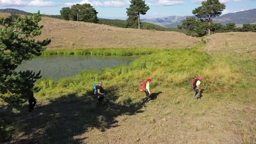 Group Of People Trekking By The Small Lake