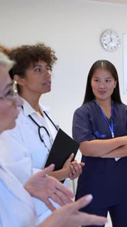 Medical Team Discussing Patient Charts in Hospital Meeting