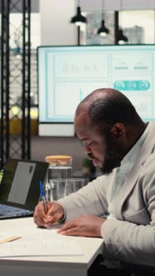 Man Signing Documents in Office Building with Coworker