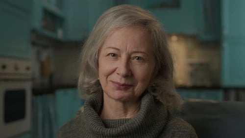 Senior Woman Smiling at Camera in Kitchen