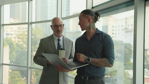 Male Manager Showing CEO Plan of Project on Laptop in Office