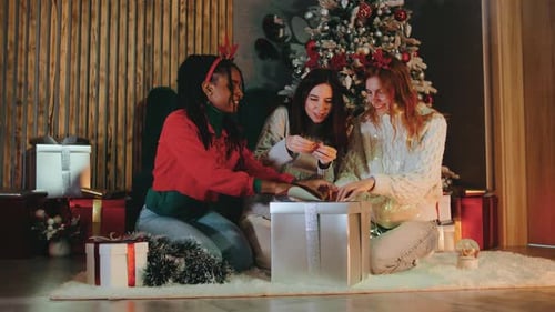 Friends Opening Christmas Presents Together Indoors