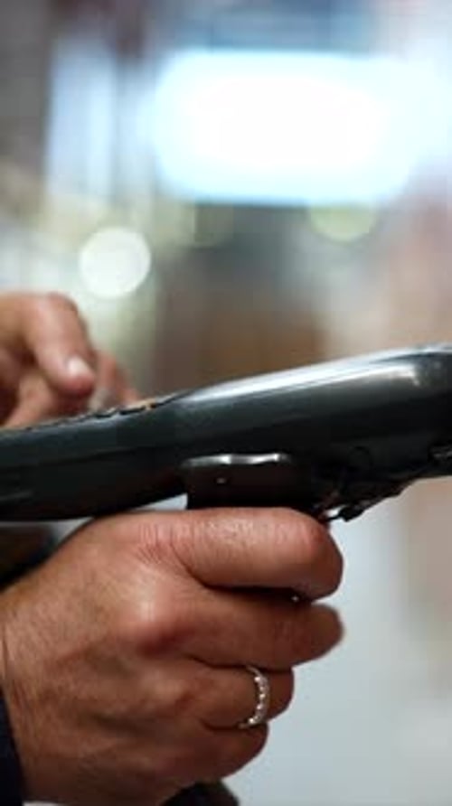 Warehouse Worker Using Handheld Barcode Scanner
