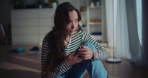 Pensive Woman Sitting on Floor in Sunlight
