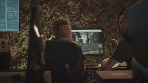 Military Workers Watching and Discussing CCTV Cameras in Office