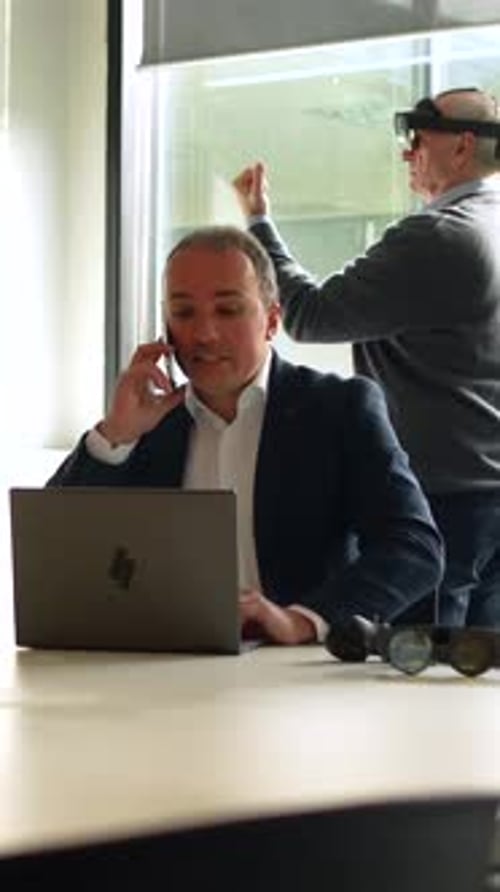 Businessmen Using Virtual Touchscreen and Laptop in the Office