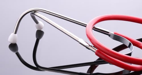 Red Stethoscope on Reflective Surface Medical Equipment