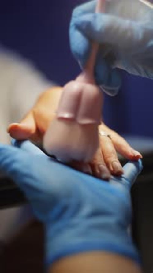 Hand Being Cleaned with Brush After Manicure
