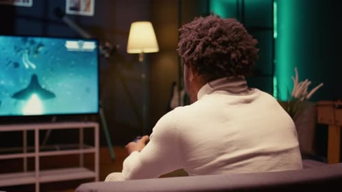 Person Playing Video Game on Television at Home
