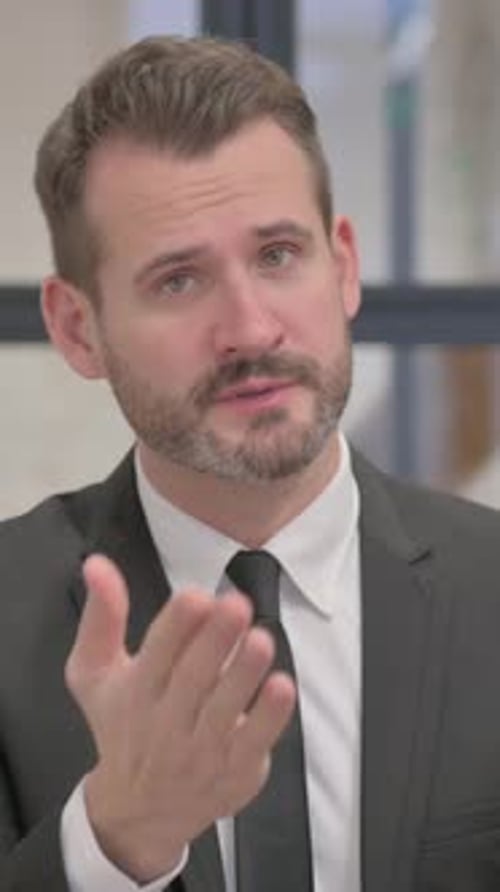 Man in Suit Speaking Directly to Camera