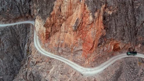 Jeep Driving on Winding Cliffside Road Carved Into Rocky Walls in Kemaliye Canyon